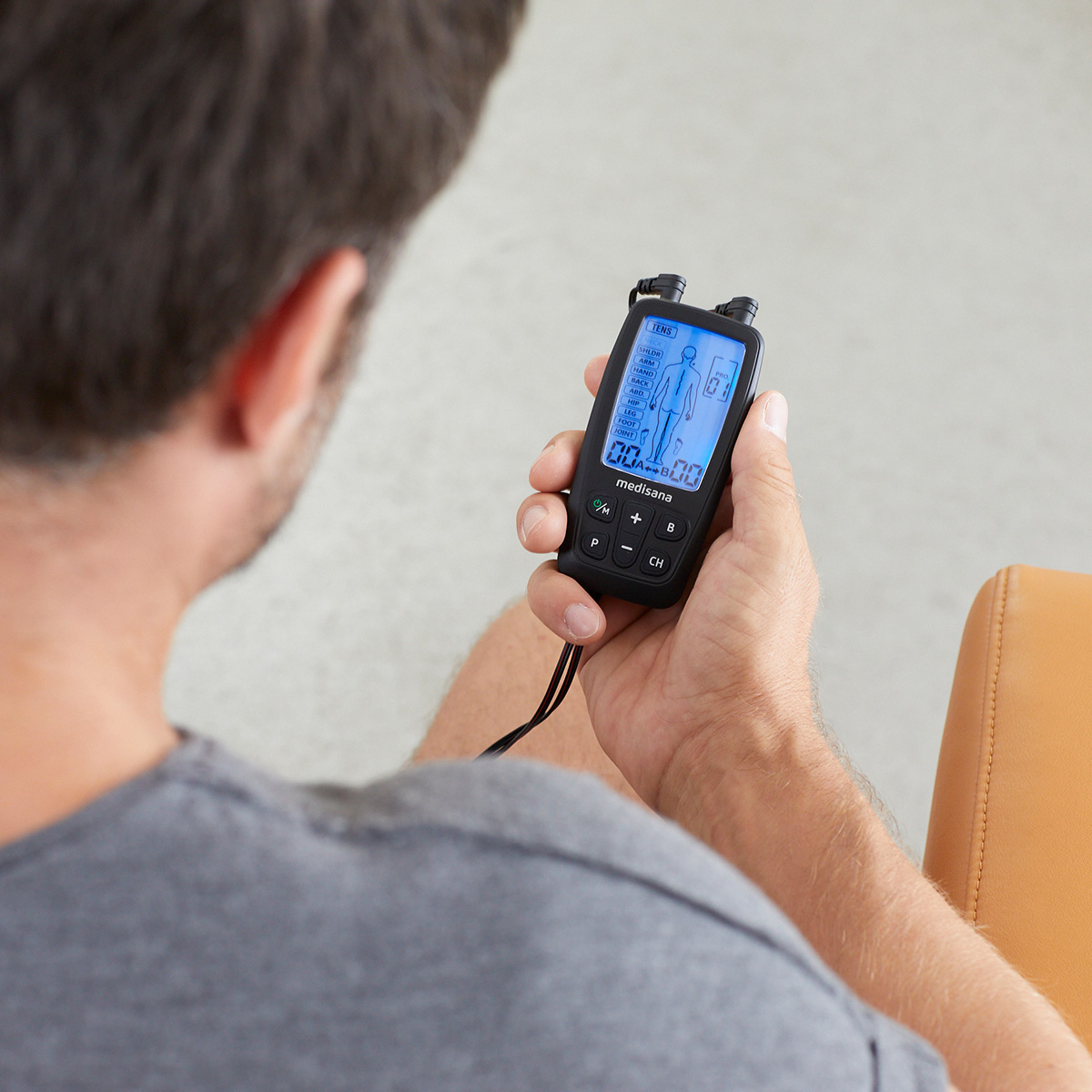 Man using a mobile TENS device for pain therapy